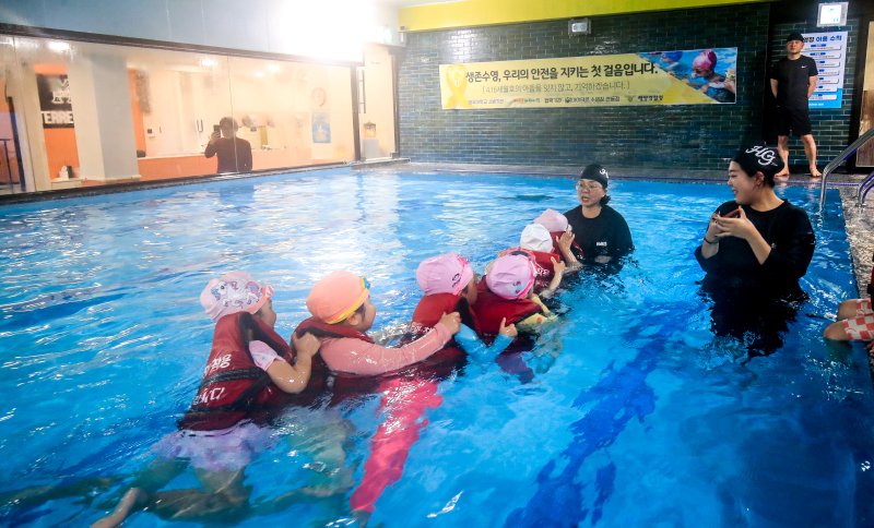 [제주=뉴시스] 우장호 기자 = 세월호 참사 11주기를 하루 앞둔 15일 오후 제주시 과원로의 한 실내 수영장에서 해오름어린이집 원아 만3~5세 어린이들이 제주해양경찰서 소속 대원들에게 생존수영을 배우고 있다. 2025.04.15. woo1223@newsis.com