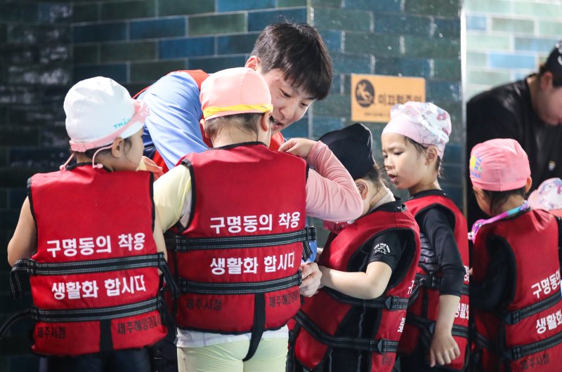 [제주=뉴시스] 우장호 기자 = 세월호 참사 11주기를 하루 앞둔 15일 오후 제주시 과원로의 한 실내 수영장에서 해오름어린이집 원아 만3~5세 어린이들이 제주해양경찰서 소속 대원들에게 생존수영을 배우고 있다. 2025.04.15. woo1223@newsis.com