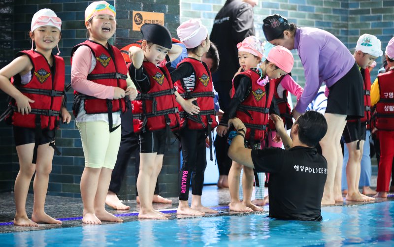 [제주=뉴시스] 우장호 기자 = 세월호 참사 11주기를 하루 앞둔 15일 오후 제주시 과원로의 한 실내 수영장에서 해오름어린이집 원아 만3~5세 어린이들이 제주해양경찰서 소속 대원들에게 생존수영을 배우고 있다. 2025.04.15. woo1223@newsis.com