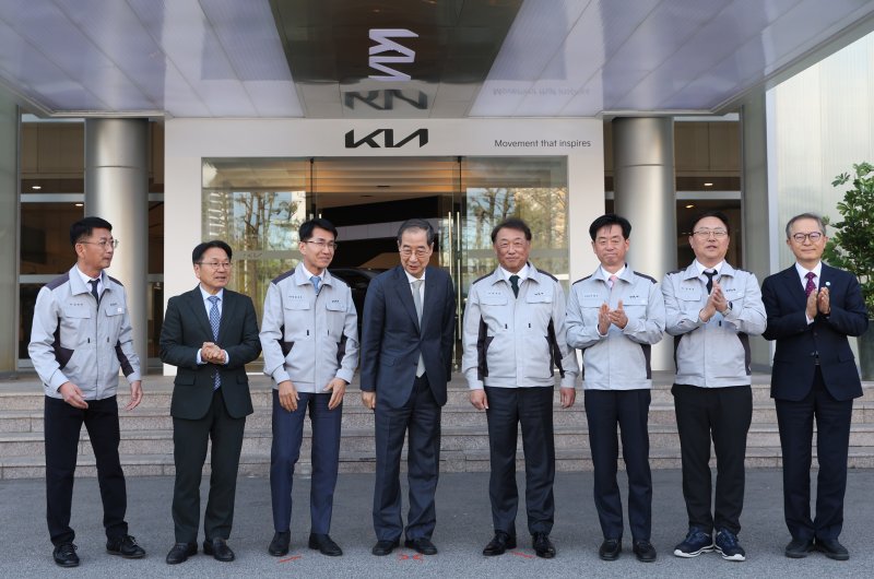 [광주=뉴시스] 조수정 기자 = 한덕수 대통령 권한대행 국무총리가 15일 자동차산업 현장방문차 광주 서구 기아오토랜드 광주공장을 찾아 기념촬영을 마친 뒤 대화하며 내부로 이동하고 있다. 왼쪽부터 김희준 현대차·기아 상무, 강기정 광주광역시장, 김동욱 현대차·기아 부사장, 한 권한대행, 최준영 기아 사장, 이항수 현대차·기아 부사장, 문재웅 기아 광주공장장(전무), 이승렬 산업통상자원부 산업정책실장.2025.04.15. chocrystal@newsis.com