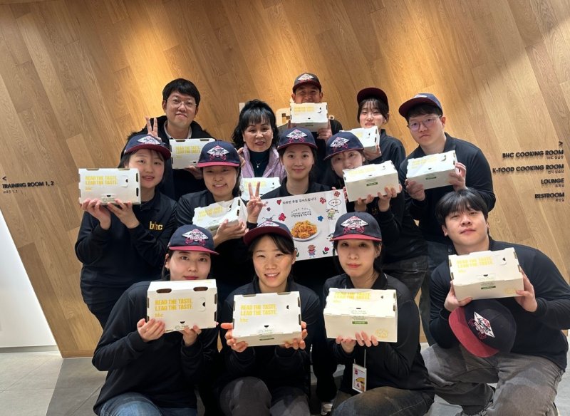 다이닝브랜즈그룹 공채 신입사원들이 사회복지시설 관계자에게 치킨을 기부하고 기념 사진을 찍고 있다. (다이닝브랜즈그룹 제공)
