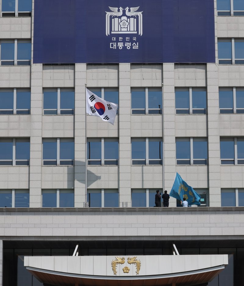 [서울=뉴시스] 조수정 기자 = 헌법재판소가 윤석열 대통령의 탄핵사건에 대해 인용을 선고한 4일 서울 용산 대통령실 청사에서 관계자들이 봉황기를 하기하고 있다. 2025.04.04. chocrystal@newsis.com