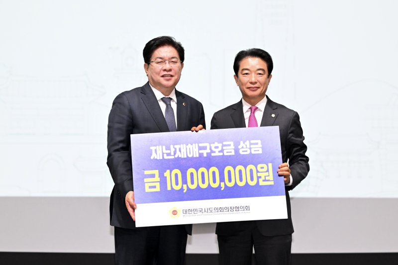 [인천=뉴시스]경상남도의회 최학범(오른쪽) 의장이 지난 15일 인천에서 열린 대한민국시도의회의장협의회 제3차 임시회에 참석해 산불 피해 재난구호금을 신청해 1000만 원을 전달받고 있다.(사진=경남도의회 제공) 2025.04.16. photo@newsis.com