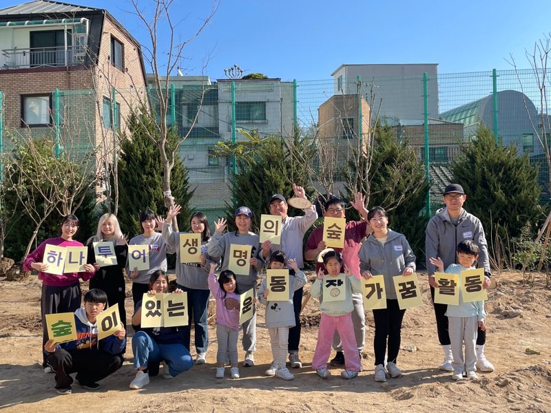 숲이 있는 운동장 조성 사업에 참여한 하나투어 임직원과 가족들이 봉사 활동 후 기념촬영을 하고 있다. 하나투어 제공