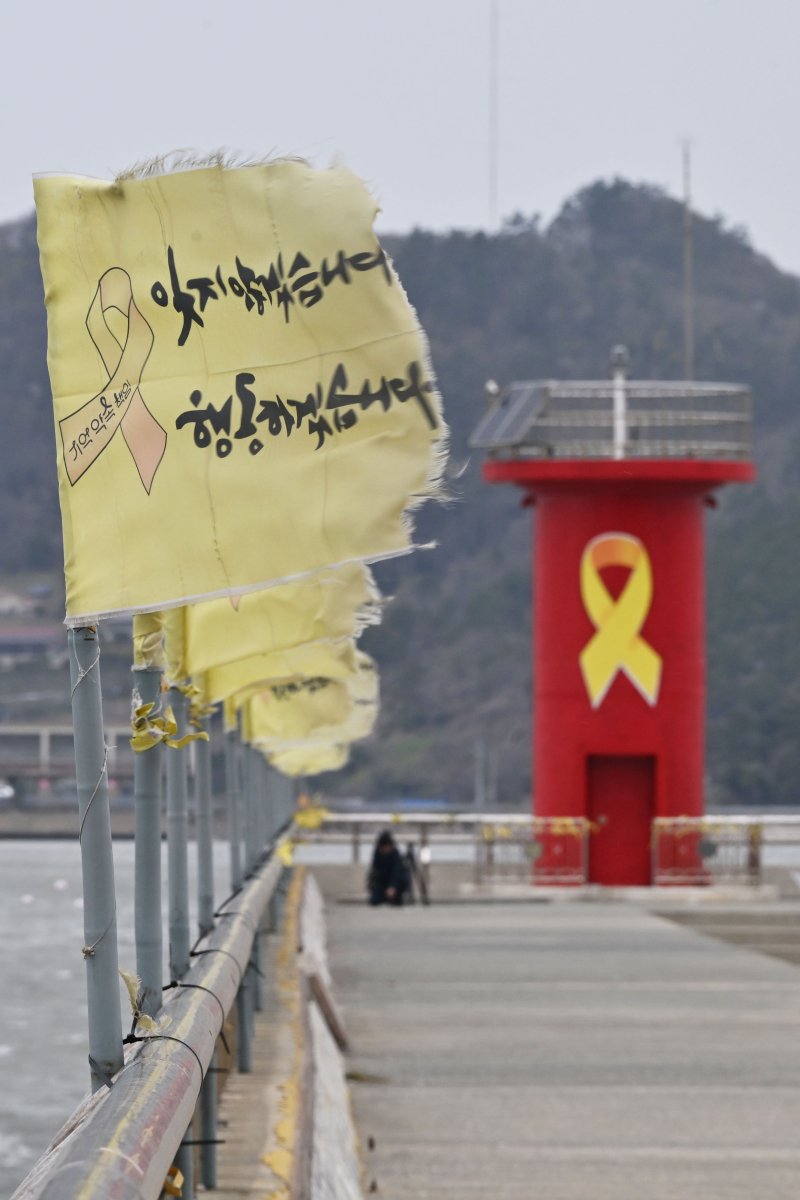 [진도=뉴시스] 이영주 기자 = 세월호 참사 11주기를 사흘 앞둔 13일 오전 전남 진도군 팽목항 세월호 등대 주변에 세워진 추모 깃발이 강한 바람에 나부끼고 있다.2025.04.13. leeyj2578@newsis.com