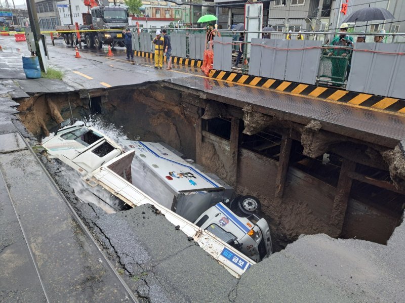 지난해 9월21일 오전 8시45분께 부산 사상구 한 도로에서 가로 10m, 세로 5m, 깊이 8m 가량의 대형 땅꺼짐 현상이 발생해 도로에서 배수 지원을 하던 삼락119안전센터 배수 차량과 5톤 트럭이 빠져있다. (부산소방재난본부 제공) 2024.9.21/뉴스1