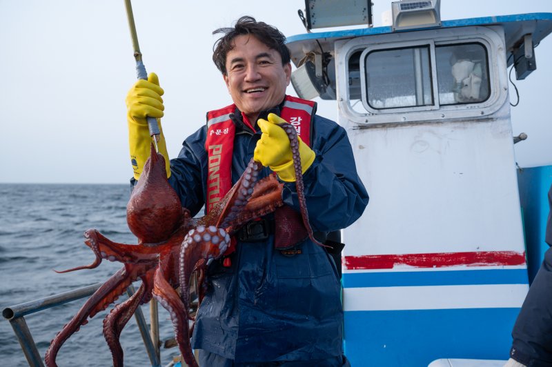 김진태 강원지사가 17일 동해 최북단 저도어장에서 어민 배위에 올라 낚시로 잡은 문어를 들어올리고 있다. 강원자치도 제공