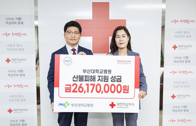 부산대병원 정성운 병원장(왼쪽)이 성금을 전달하며 박선영 대한적십자사 부산지사 사무처장과 기념촬영을 하고 있다. 부산대병원 제공