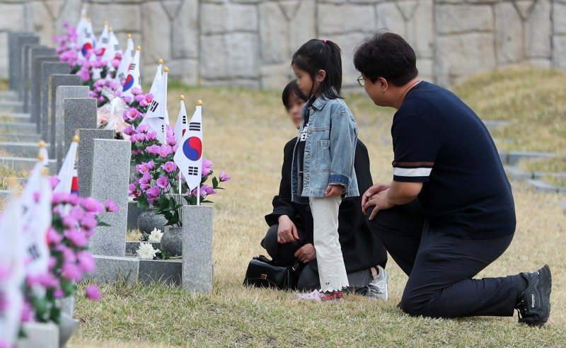 [서울=뉴시스] 김혜진 기자 = 4.19 혁명 기념일을 하루 앞둔 18일 오전 서울 강북구 국립 4.19민주묘지에서 유족이 묘비를 살피고 있다. 2025.04.18. jini@newsis.com