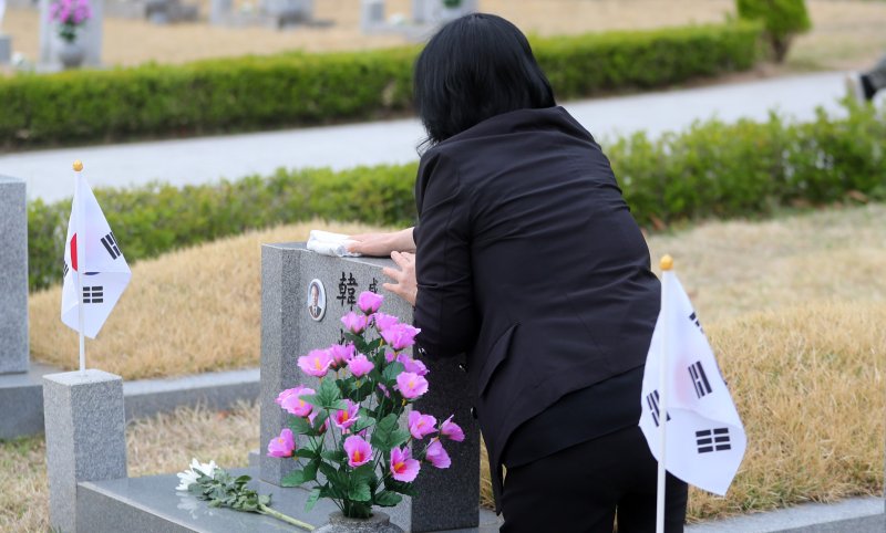 [서울=뉴시스] 김혜진 기자 = 4.19 혁명 기념일을 하루 앞둔 18일 오전 서울 강북구 국립 4.19민주묘지에서 유족이 묘비를 닦고 있다. 2025.04.18. jini@newsis.com