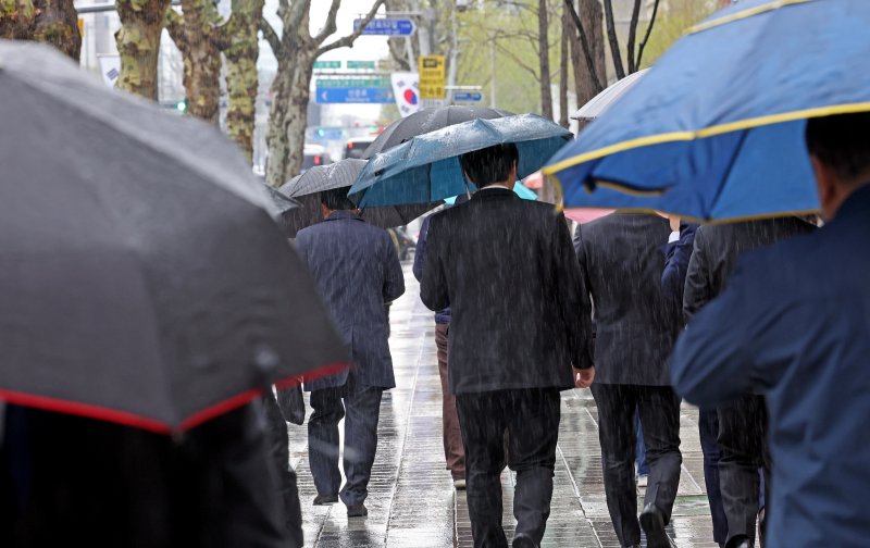 쌀쌀한 봄 날씨 속 종일 비가 내리다 그치기를 반복한 지난 14일 서울 강남구 테헤란로에서 시민들이 우산을 쓰고 이동하고 있다. /사진=뉴시스