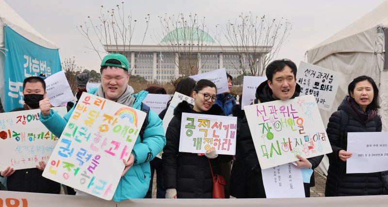 장애인 인권 단체 회원들이 2일 서울 여의도 국회 앞에서 가진 기자회견에서 장애인 참정권 보장을 촉구하고 있다. 이들은 모든 사람이 접근 가능한 투표소 선정과 수어통역·자막 제공 의무화, 이해하기 쉬운 선거 정보 제공 등을 22대 총선에서 제공할 것을 국회에 촉구했다. 2024.1.2/뉴스1 ⓒ News1 신웅수 기자