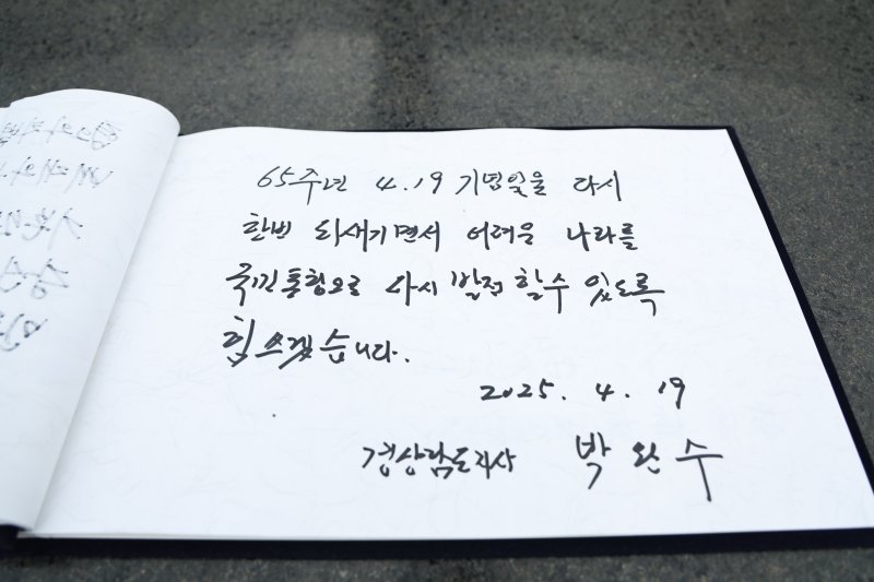 제65주년 4.19 혁명 기념일인 19일 박완수 지사가 국립 3.15 민주묘지를 찾아 참배하고 참배록에 글을 남겼다.(경남도 제공. 재판매 및 DB금지)