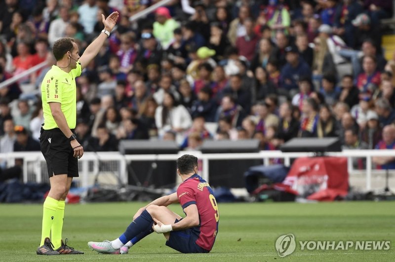 왼쪽 허벅지를 잡고 주저앉은 바르셀로나의 로베르트 레반도프스키 (출처=연합뉴스)