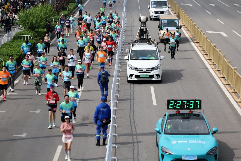 [베이징=신화/뉴시스] 19일 중국 베이징 이좡 경제기술개발구에서 열린 하프마라톤에서 인간과 로봇 참가자들이 나란히 달리고 있다. 2025.04.20