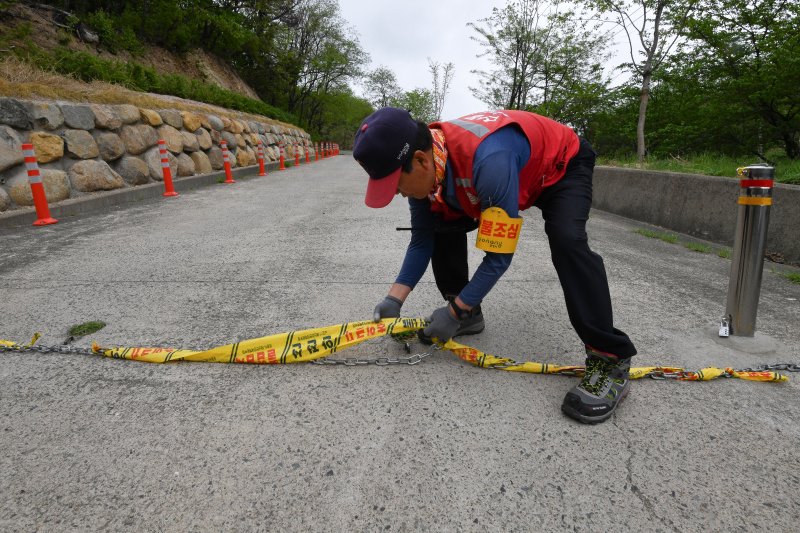 경북 포항시가 산불 예방 행위제한 입산금지 행정명령을 20일부터 전면 해제한 가운데 남구 인덕산 자연마당으로 들어가는 입구에서 산불감시원이 출입금지 알림 표시줄을 제거하고 있다. 2025.4.20/뉴스1 ⓒ News1 최창호 기자
