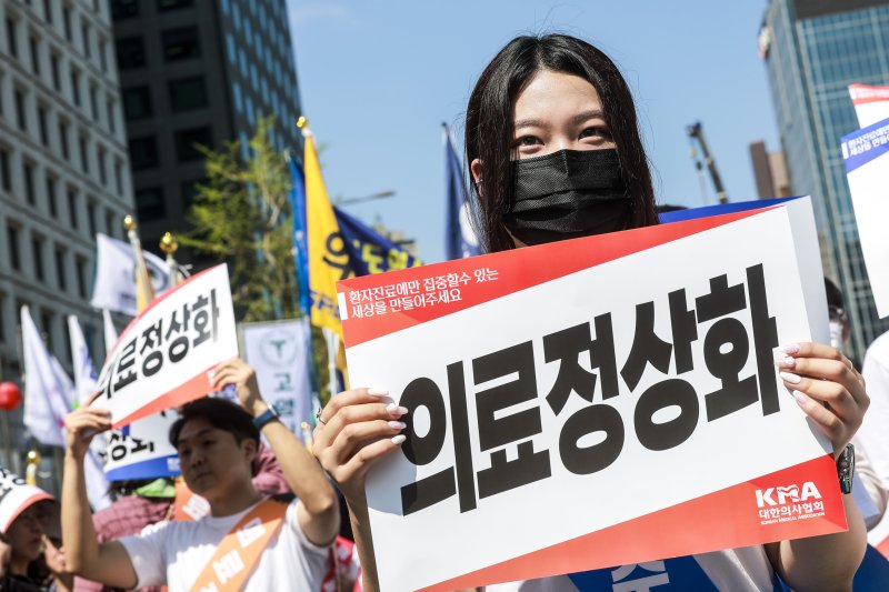 [서울=뉴시스] 정병혁 기자 = 20일 서울 중구 세종대로에서 열린 의료정상화를 위한 전국의사궐기대회에 참가한 의대생과 대한의사협회 관계자들이 피켓을 들고 있다. 2025.04.20. jhope@newsis.com