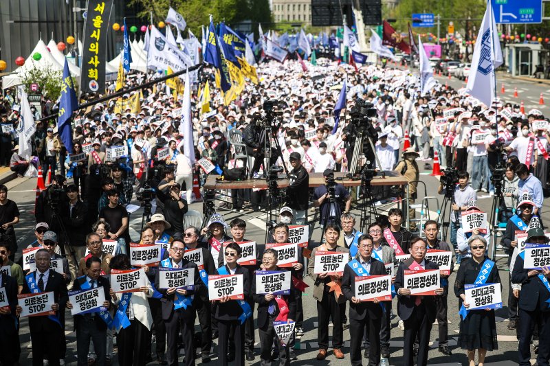 [서울=뉴시스] 정병혁 기자 = 20일 서울 중구 세종대로에서 열린 의료정상화를 위한 전국의사궐기대회에 참가한 의대생과 대한의사협회 관계자들이 피켓을 들고 있다. 2025.04.20. jhope@newsis.com