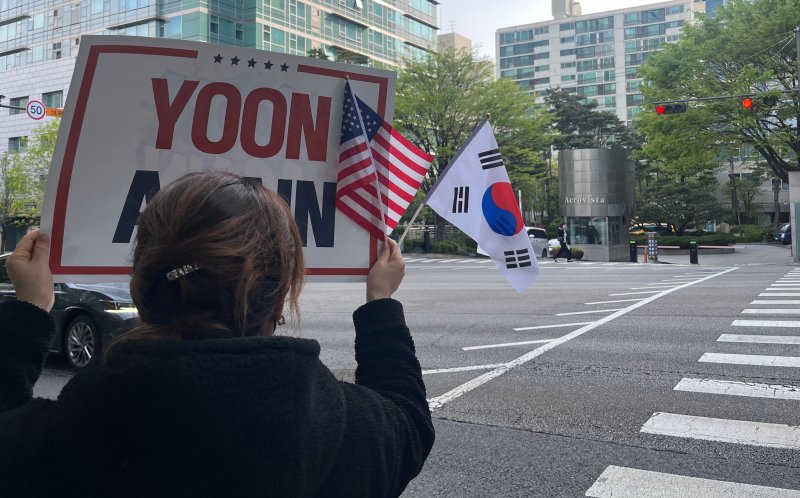 21일 오전 8시 40분쯤 서울 서초구 서초동 윤석열 전 대통령 사저 입구에서 지지자들이 응원하고 있다.2025.4.21/뉴스1 김종훈 기자