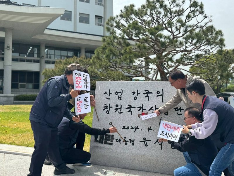 민주노총 경남본부가 21일 창원시 성산구 외동 한국산업단지공단 경남본부 앞에 설치된 윤석열 전 대통령 친필 표지석에서 철거를 촉구하는 기자회견을 열고 철거 퍼포먼스를 하고 있다.(민주노총 경남본부 제공. 재판매 및 DB금지)