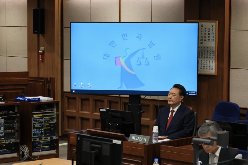 [서울=뉴시스] 사진공동취재단 = 12·3 비상계엄을 선포해 내란 우두머리 혐의로 재판에 넘겨진 윤석열 전 대통령이 21일 오전 서울 서초구 서울중앙지법 417호 법정에 앉아 재판 시작을 기다리고 있다. 2025.04.21. photo@newsis.com