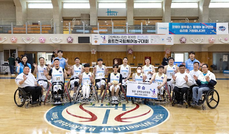 코웨이 블루휠스 휠체어농구단 선수들이 지난 20일 고양시 홀트장애인종합체육관에서 열린 제30회 홀트전국휠체어농구대회에서 우승을 차지한 뒤 기념 촬영을 하고 있다. 코웨이 제공
