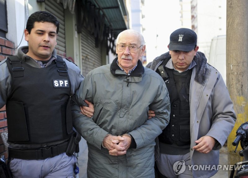 경찰에 연행되는 호르헤 라파일 비델라(가운데, 2012.7.17) (출처=연합뉴스)