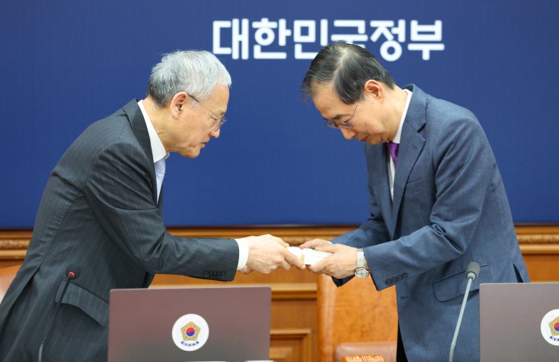 [서울=뉴시스] 고범준 기자 = 한덕수 대통령 권한대행 국무총리가 세계 책의 날을 하루 앞둔 22일 서울 종로구 정부서울청사에서 열린 국무회의에 참석해 유인촌 문화체육관광부 장관으로부터 책 선물을 받고 있다. 2025.04.22. 2025.04.22. bjko@newsis.com