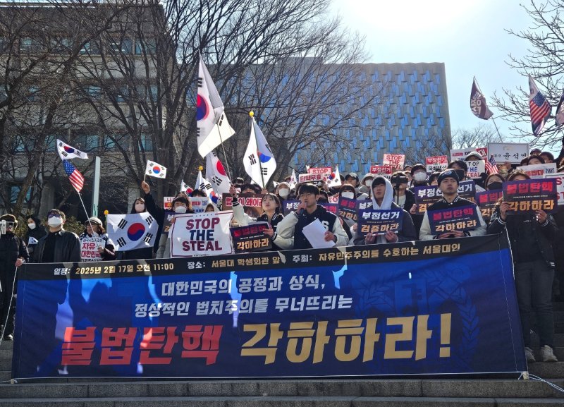 [서울-뉴시스] 오정우 기자 = 반면 탄핵 반대를 주장하는 학생들은 행진 대열을 막아세운 채 부부젤라와 확성기를 불거나 '탄핵 무효' '불법 탄핵' 구호를 외치는 등 맞불 집회를 펼쳤다. 2025.02.17. friend@newsis.com *재판매 및 DB 금지