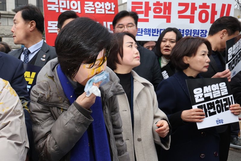 백혜련 더불어민주당 의원이 20일 오전 서울 종로구 헌법재판소 앞에서 가진 윤석열 대통령 신속 파면 촉구 기자회견에서 윤 대통령 지지자가 던진 계란을 닦고 있다. 2025.3.20/뉴스1 ⓒ News1 신웅수 기자