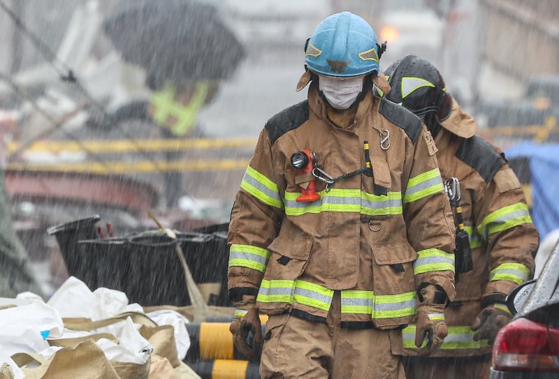 비가 내리는 14일 경기 광명시 일직동 신안산선 복선전철 5-2공구 붕괴 현장에서 소방관들이 이동하고 있다. 2025.4.14/뉴스1 ⓒ News1 김도우 기자