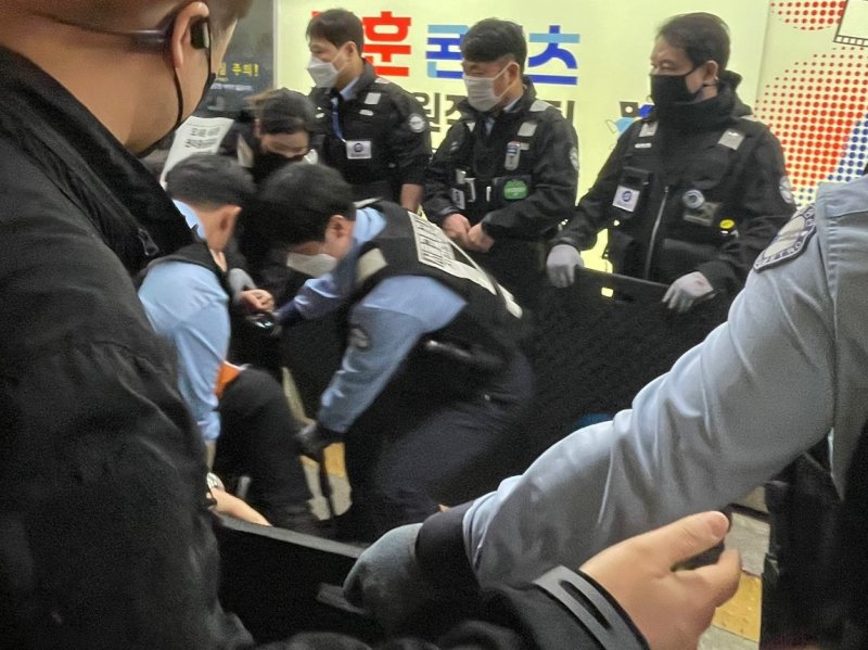 [서울=뉴시스] 권도인 인턴기자 = 서울교통공사 관계자가 23일 오전 8시15분께 불법시위를 이유로 지하철보안관 등 6명을 동원해 이형숙 전국장애인차별철폐연대(전장연) 상임공동대표를 서울 지하철 4호선 혜화역 승강장에서 끌어내고 있다. 혜화역에서 시위를 이어가고 있는 전장연 시위대는 이틀 연속으로 강제퇴거당했다. 2025.04.23. photo@newsis.com