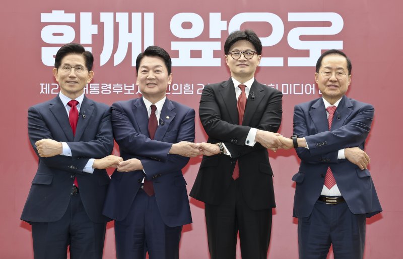 23일 서울 영등포구 국민의힘 중앙당사에 열린 2차경선 토론회 미디어데이에서 대선 경선 후보인 김문수·안철수·한동훈·홍준표 후보(왼쪽부터)가 손을 맞잡고 기념촬영을 하고 있다. 연합뉴스