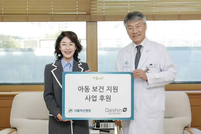 이어룡 대신파이낸셜그룹 회장(왼쪽)과 박승일 서울아산병원장(오른쪽)이 지난 23일 서울아산병원 병원장실에서 아동 보건 지원 사업 후원금 전달식을 갖고 사진을 촬영하고 있다. 대신증권 제공
