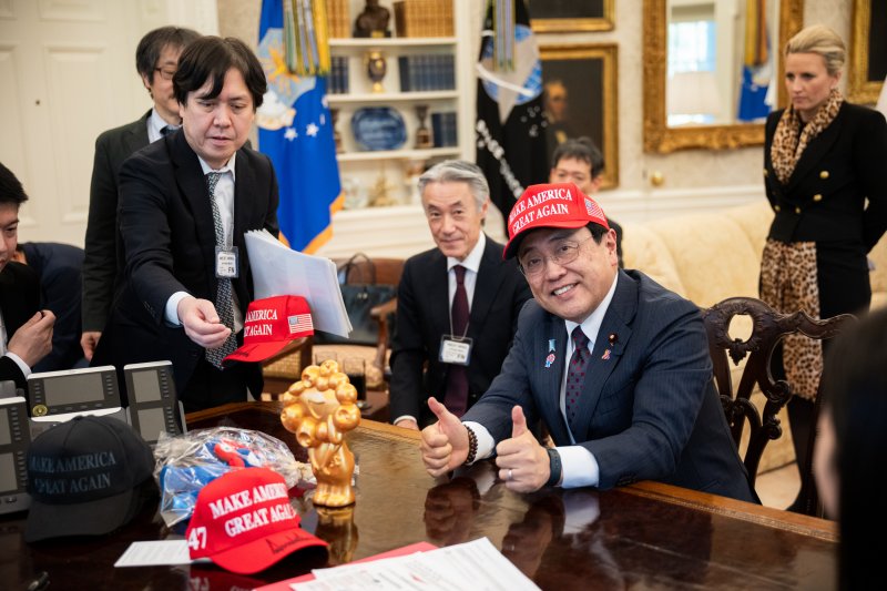 지난 4월 16일(현지시간) 미국 워싱턴DC 백악관 집무실을 찾은 아카자와 료세이 일본 경제재생상이 도널드 트럼프 미국 대통령이 서명해 건네 준 '마가(MAGA, 미국을 다시 위대하게' 모자를 써보고 있다.(출처 백악관) 사진=뉴스1