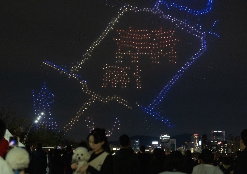 [서울=뉴시스] 김명년 기자 = 27일 오후 서울 광진구 뚝섬한강공원 수변무대에서 2025 한강 불빛 공연(드론 라이트 쇼)이 펼쳐지고 있다. 2025.04.27. kmn@newsis.com