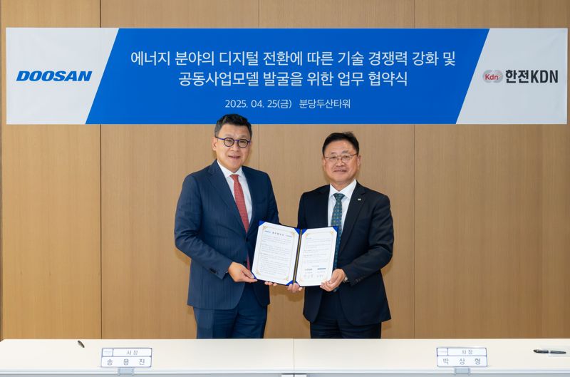 송용진 두산에너빌리티 전략·혁신부문장(왼쪽)이 25일 분당두산타워에서 진행된 '에너지 분야 디지털 전환에 따른 기술 경쟁력 강화 및 공동사업 모델 발굴' 업무협약식에서 박상형 한전KDN 사장과 기념촬영을 하고 있다. 두산에너빌리티 제공