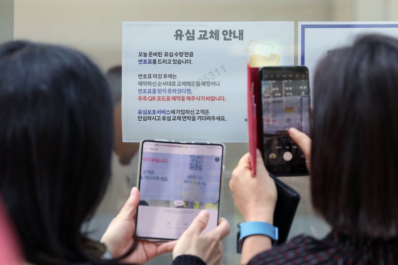 해킹 공격으로 가입자 유심 정보가 탈취된 SK텔레콤이 가입자 유심 무상 교체를 시작한 28일 오전 서울 종로구 T월드 직영매장 앞에서 번호표를 받지 못한 고객들이 온라인 예약을 하고 있다. 2025.4.28/뉴스1 ⓒ News1 박정호 기자