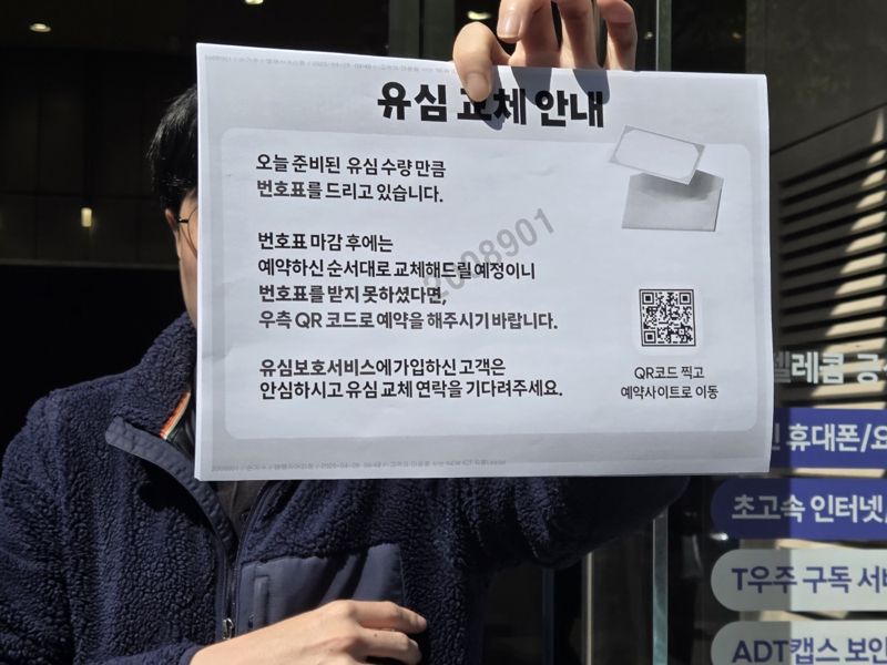 SK텔레콤 대리점에 유심 교체를 하려는 사람들이 몰린 가운데 대리점 직원이 유심 교체 안내를 하고 있다. 사진=구자윤 기자