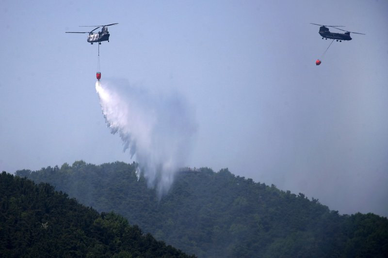 대구 북구 함지산 산불 이틀째인 29일 오후 산불 진화 작전에 투입된 군용 헬기가 함지산 상공에서 물을 뿌리고 있다. 뉴스1