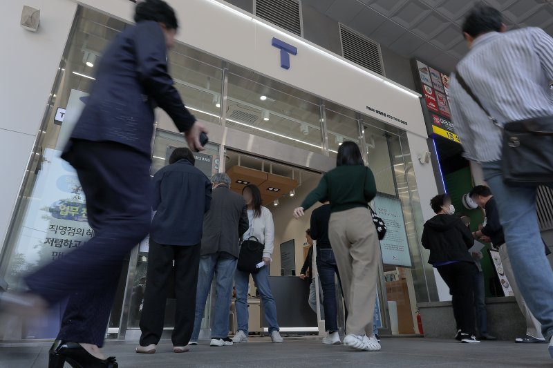 해킹 공격으로 가입자 유심 정보가 탈취된 SK텔레콤이 가입자 유심 무상 교체를 시작한 28일 오전 서울 종로구 T월드 매장 앞에서 고객들이 온라인 예약을 안내 받고 있다. 2025.4.28/뉴스1 ⓒ News1 박정호 기자