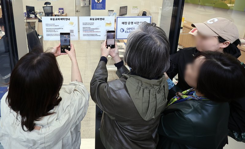 SK텔레콤 가입자 유심(USIM) 정보 해킹 사고 관련 유심 무료교체 서비스 이틀 째인 29일 오전 서울 종로구 T월드 직영 매장 앞에서 번호표를 받지 못한 고객들이 온라인 예약을 하고 있다. 2025.4.29/뉴스1 ⓒ News1 김진환 기자