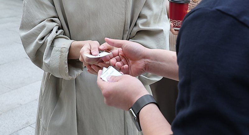 SK텔레콤 가입자 유심(USIM) 정보 해킹 사고 관련 유심 무료교체 서비스 이틀 째인 29일 오전 서울 종로구 T월드 직영 매장 앞에서 매장 관계자가 고객에게 번호표를 전달하고 있다. 2025.4.29/뉴스1 ⓒ News1 김진환 기자