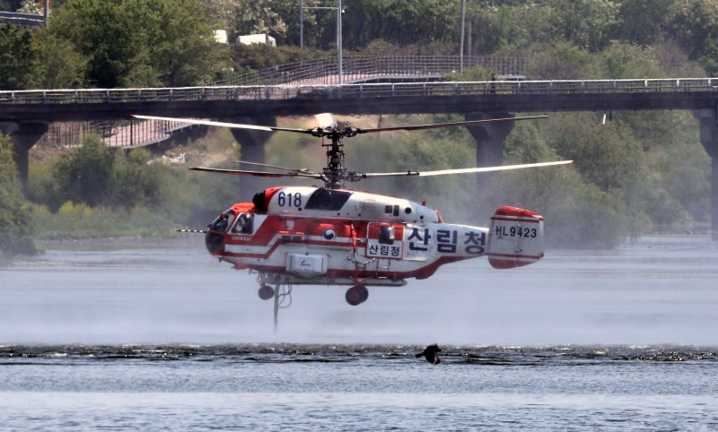 [대구=뉴시스] 이무열 기자 = 대구 북구 함지산 산불 이틀째인 29일 대구 북구 금호강에서 산불진화헬기가 담수하고 있다. 2025.04.29. lmy@newsis.com