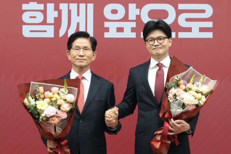 국민의힘 2차 경선 결선에 진출한 김문수, 한동훈(오른쪽) 후보가 29일 오후 서울 여의도 중앙당사에서 열린 제21대 대통령후보자 선출을 위한 3차 경선 진출자 발표에서 꽃다발을 들고 기념촬영을 하고 있다. 뉴시스