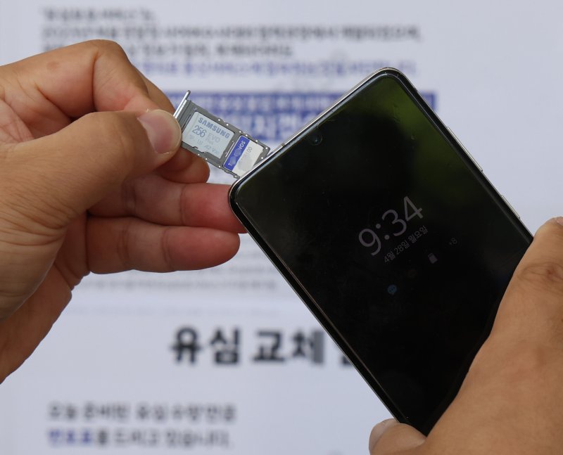 28일 오전 서울 시내 한 SKT 대리점에서 한 이용자가 유심을 교체하고 있다. 뉴시스