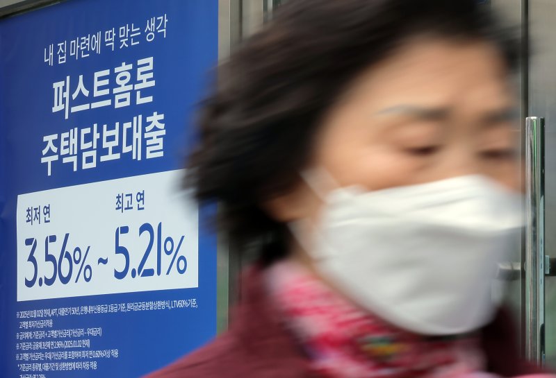 서울 시내의 한 은행 입구에 주택담보대출 상품 금리 홍보물 앞으로 시민이 지나고 있다. /뉴스1 ⓒ News1 박정호 기자