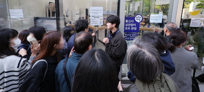 SK텔레콤 가입자 유심(USIM) 정보 해킹 사고 관련 유심 무료교체 서비스 이틀 째인 29일 오전 서울 종로구 T월드 직영 매장 앞에서 매장 관계자가 번호표를 받지 못한 고객들에게 온라인 예약을 안내하고 있다. 2025.4.29/뉴스1 ⓒ News1 김진환 기자