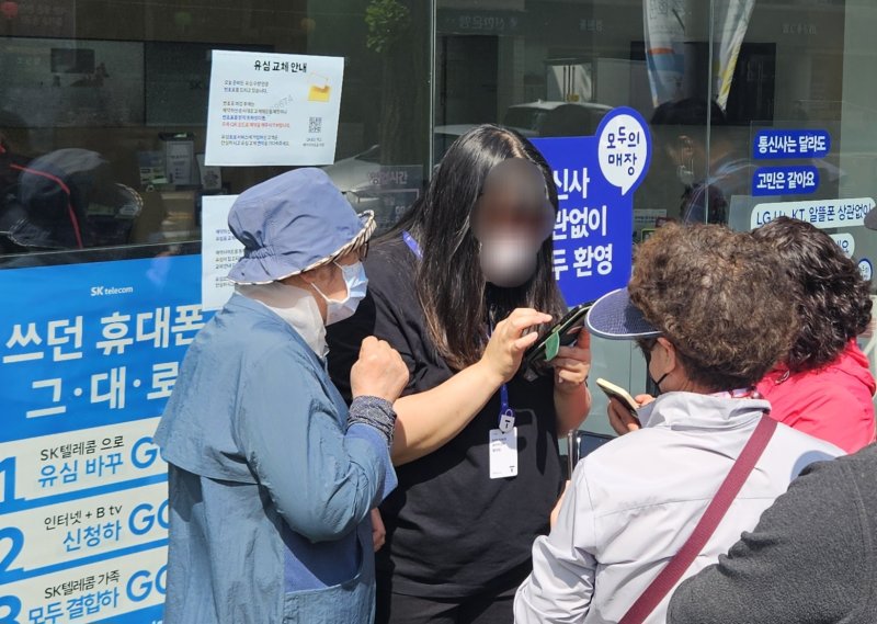 전북자치도 전주시의 한 SK텔레콤 대리점 직원이 유심 무상 교체 온라인 예약 방법을 안내하고 있다. 뉴스1/ 신준수 기자