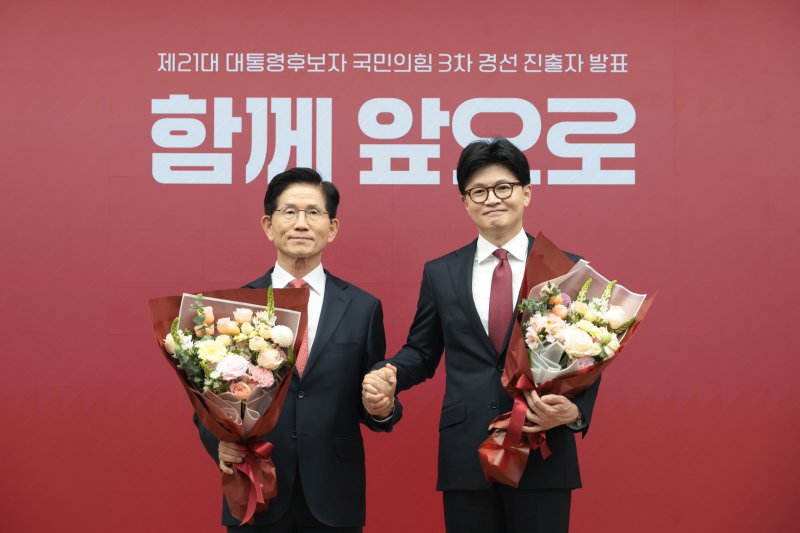 김문수(왼쪽), 한동훈 국민의힘 대선 경선 후보가 29일 서울 여의도 국민의힘 당사에서 열린 제21대 대통령 후보자 국민의힘 3차 경선 진출자 발표 행사에서 꽃다발을 들고 기념촬영을 하고 있다. 2025.4.29/뉴스1 ⓒ News1 국회사진취재단